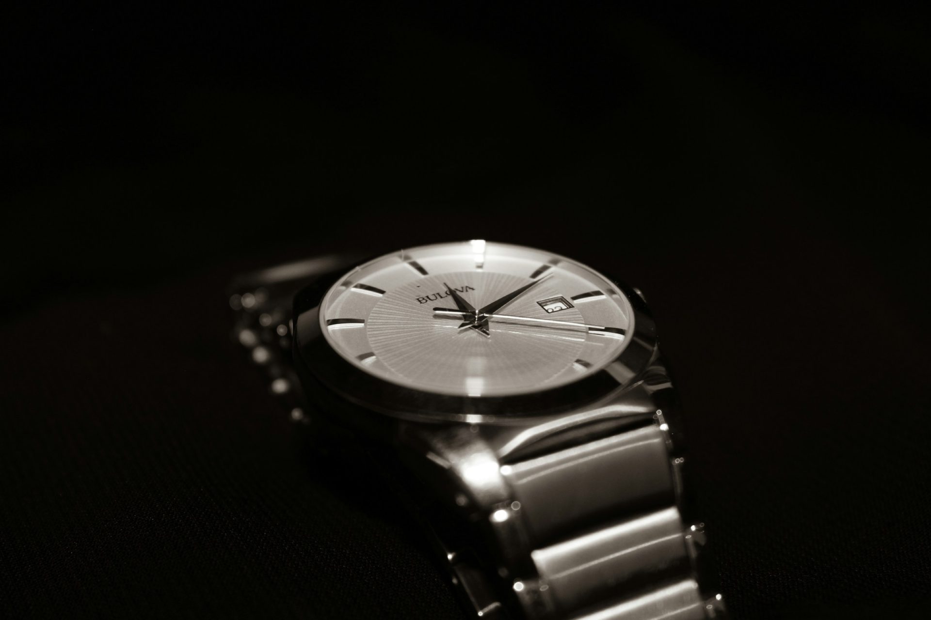 Steel watch with a silver dial and bracelet in low light
